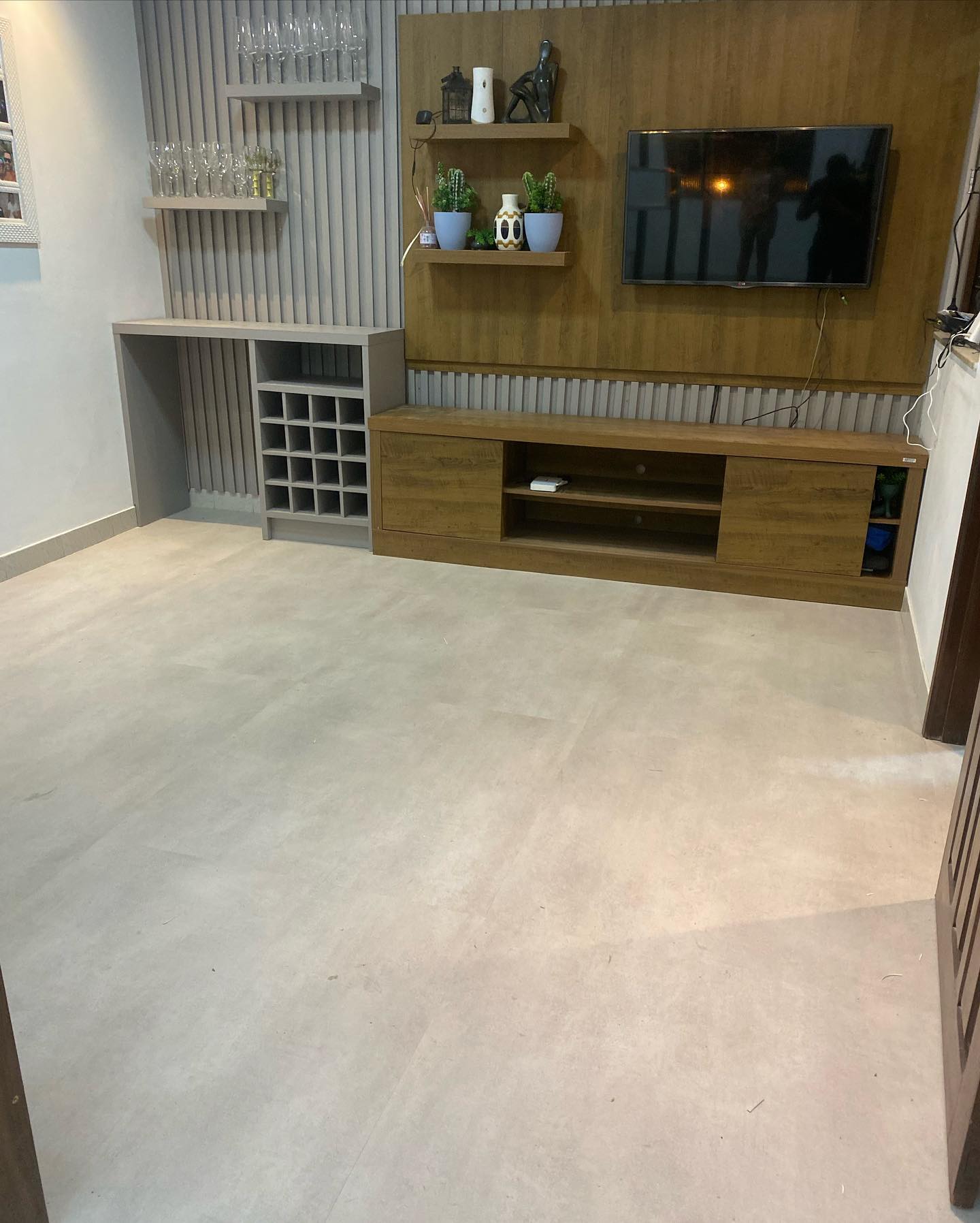 Sala aconchegante com painel de TV e piso vinílico instalado
